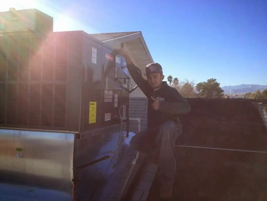 HVAC technician performing HVAC Inspection on a rooftop unit in Shakopee